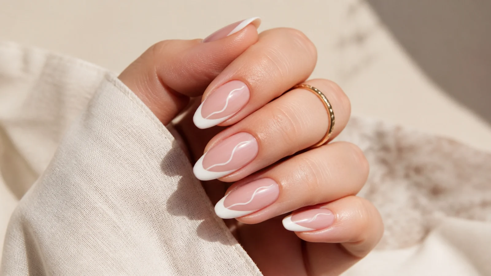 Medium almond nails with a white French tip and a thin swirling line curling down the nail bed