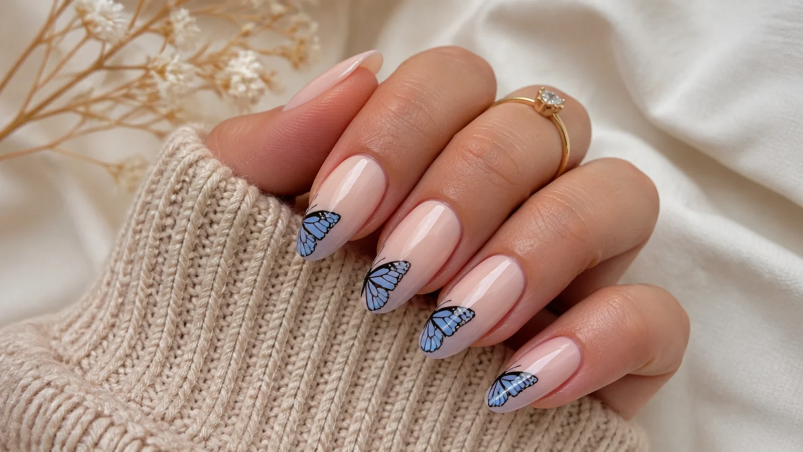 Long almond nails with sheer bases and a single blue and black butterfly painted over the tip area