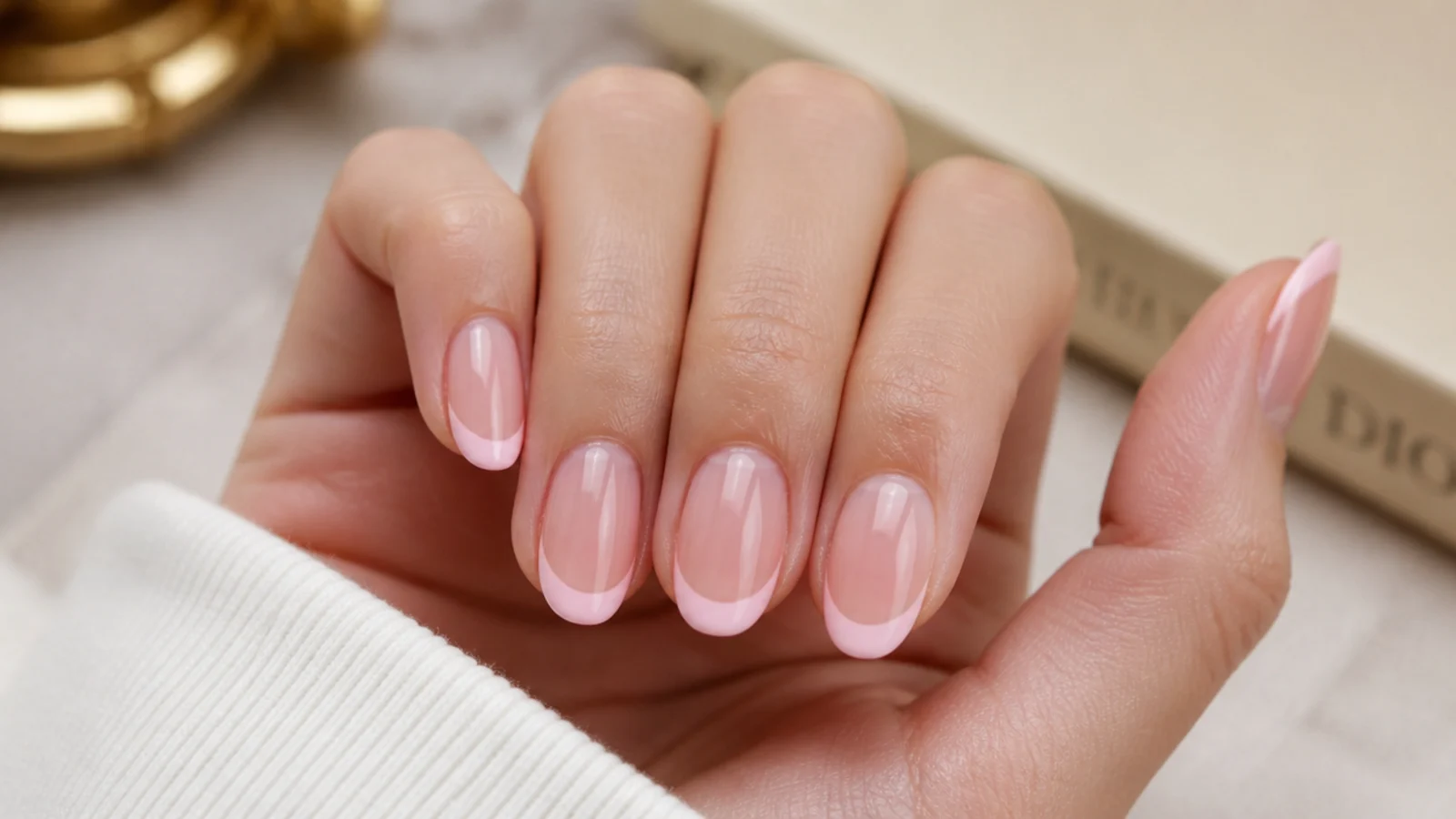 Short almond nails with a soft pink French tip and glossy bare nail beds in clean girl style