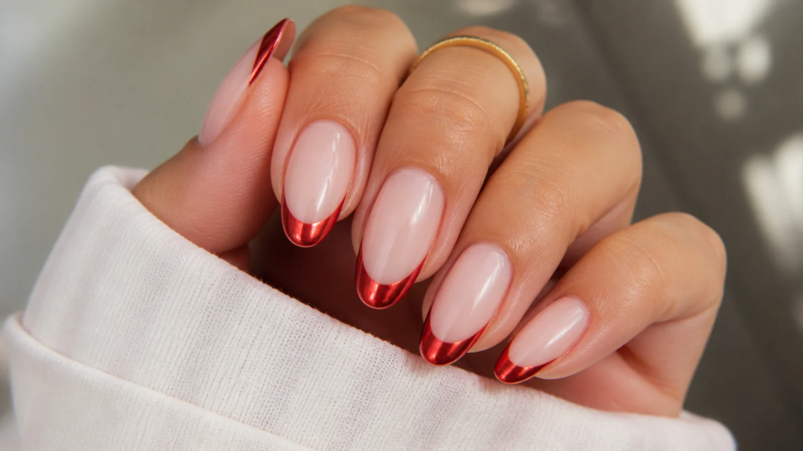 Long almond nails with mirror red chrome French tips over a milky nude base