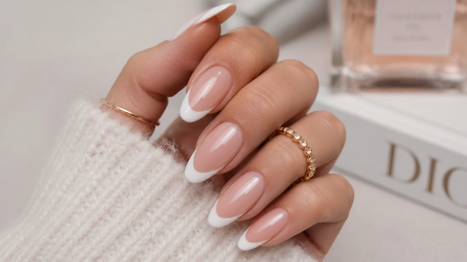 Long almond nails with white French tips curving to follow the tapered point