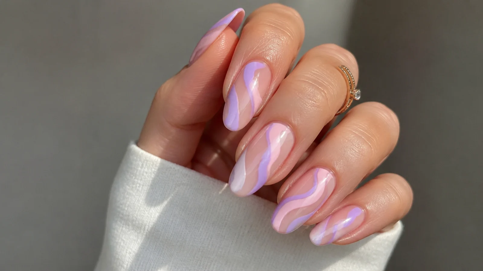 Soft pink and lavender swirl acrylic nails with wavy lines