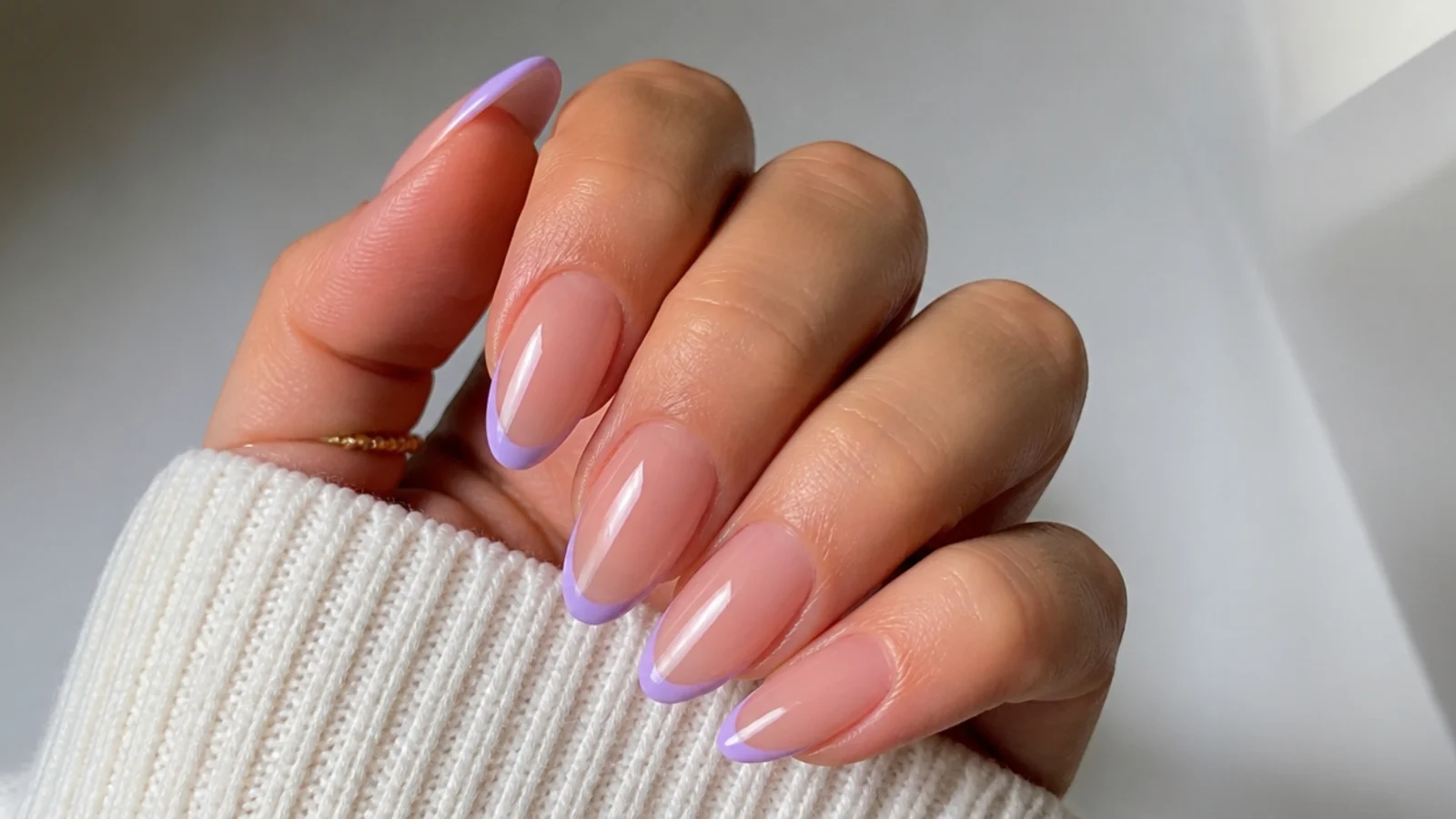 Almond acrylic nails with thin lavender micro-French tips on a clear base