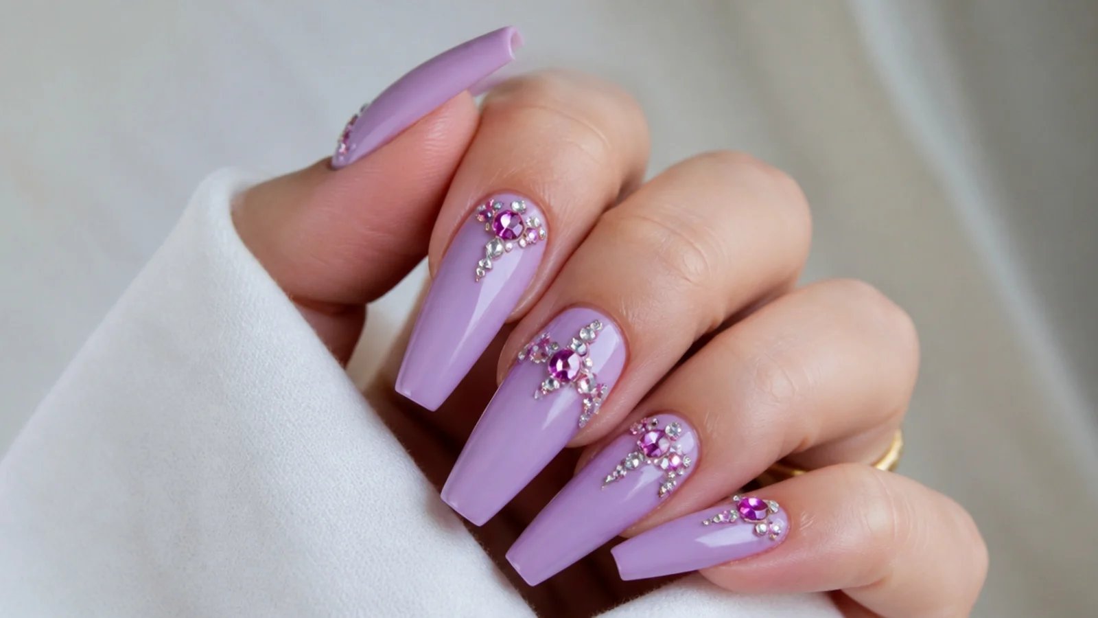 Lavender acrylic nails with clustered clear and lilac rhinestones