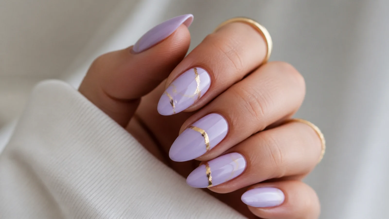 Soft lavender almond nails with thin gold foil accent lines