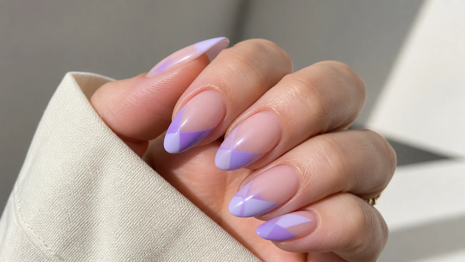 Almond nails with lavender geometric shapes over bare negative space