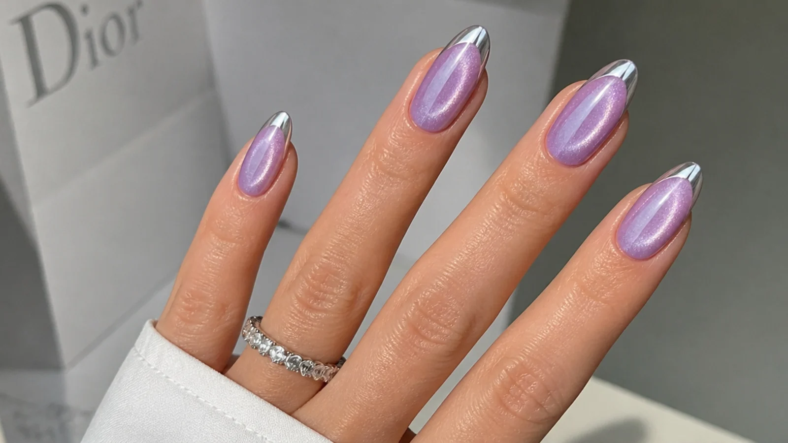 Lavender cat eye nails with silver chrome tips and a glowing center line