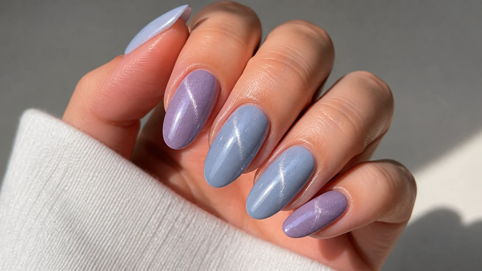 Alternating lavender and baby blue cat eye nails with matching light streaks