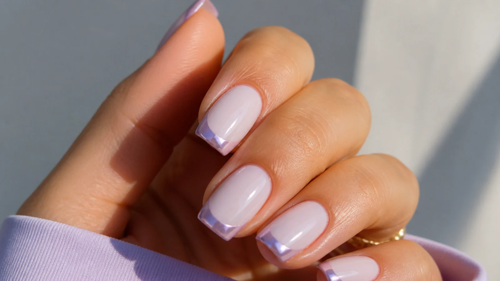 Milky base lavender chrome French tip nails on a squoval shape