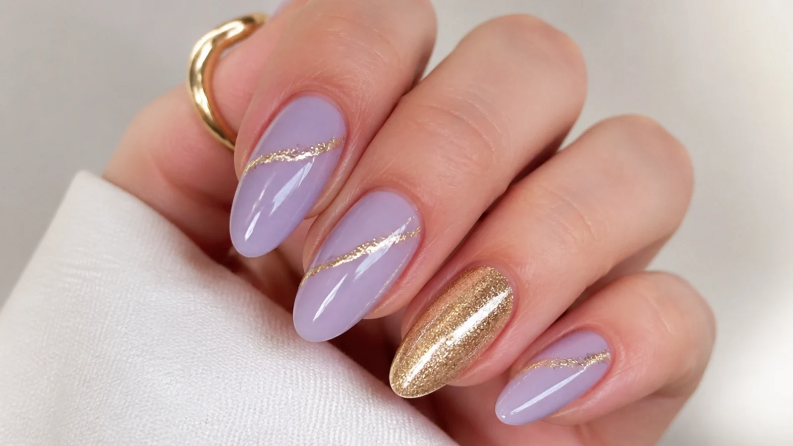 Lavender nails with thin gold foil lines and a gold accent nail