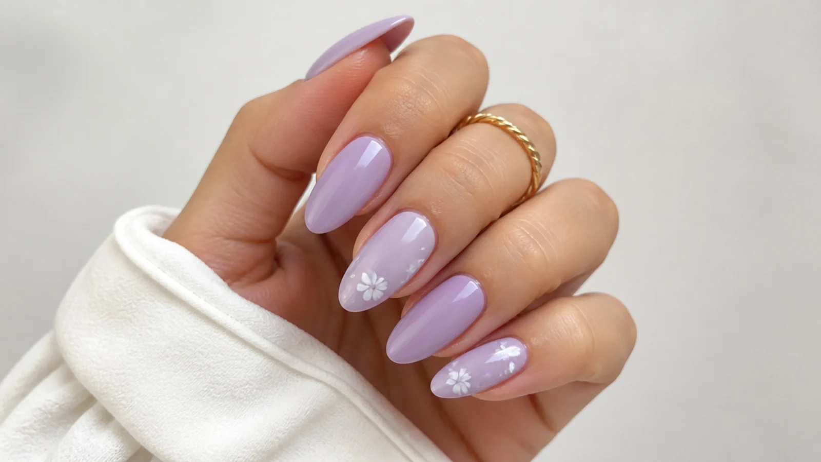 Soft milky lavender almond nails on a light background