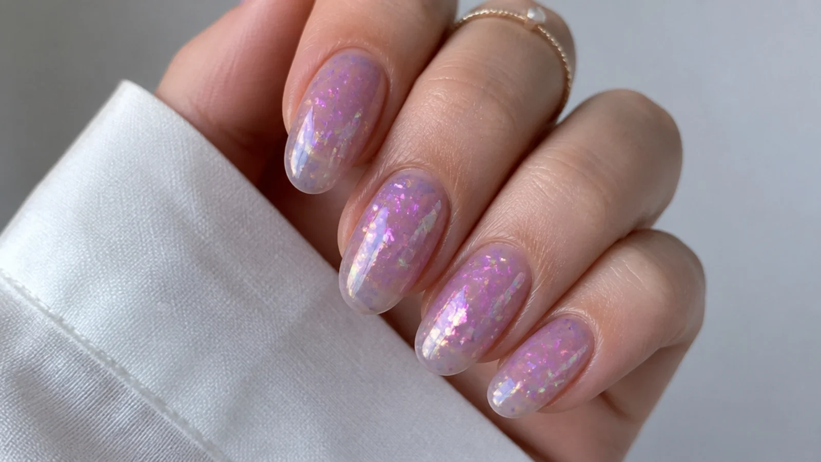 Sheer lavender nails scattered with iridescent color-shifting flakes