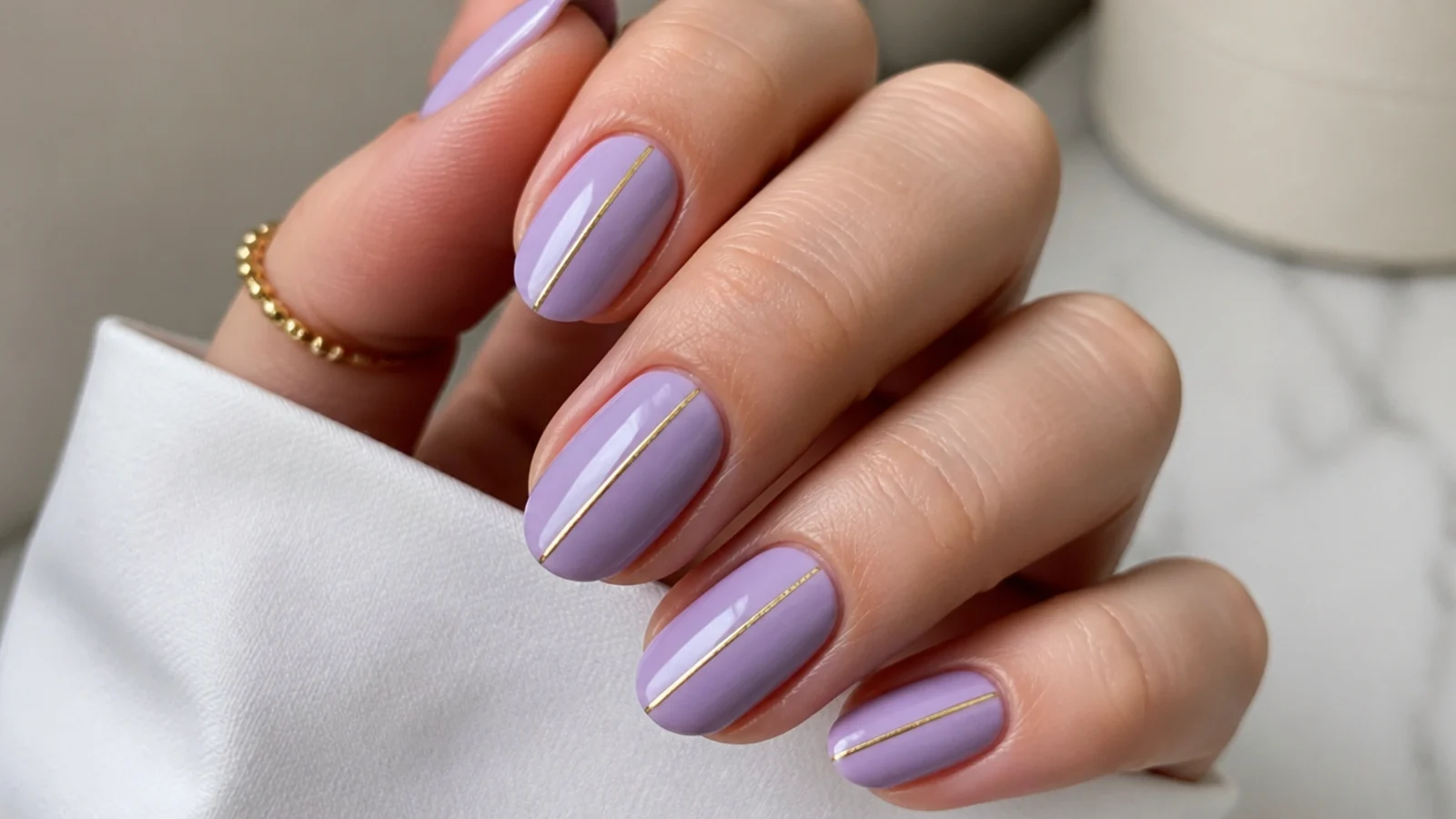 Solid lavender nails with a single thin gold chrome stripe down each nail