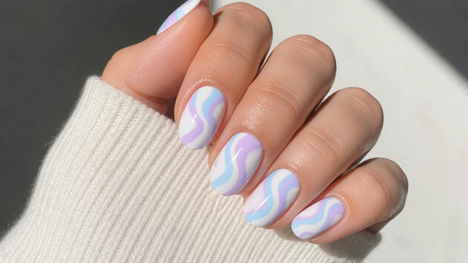 Lavender and baby blue swirl pattern nails on a white base