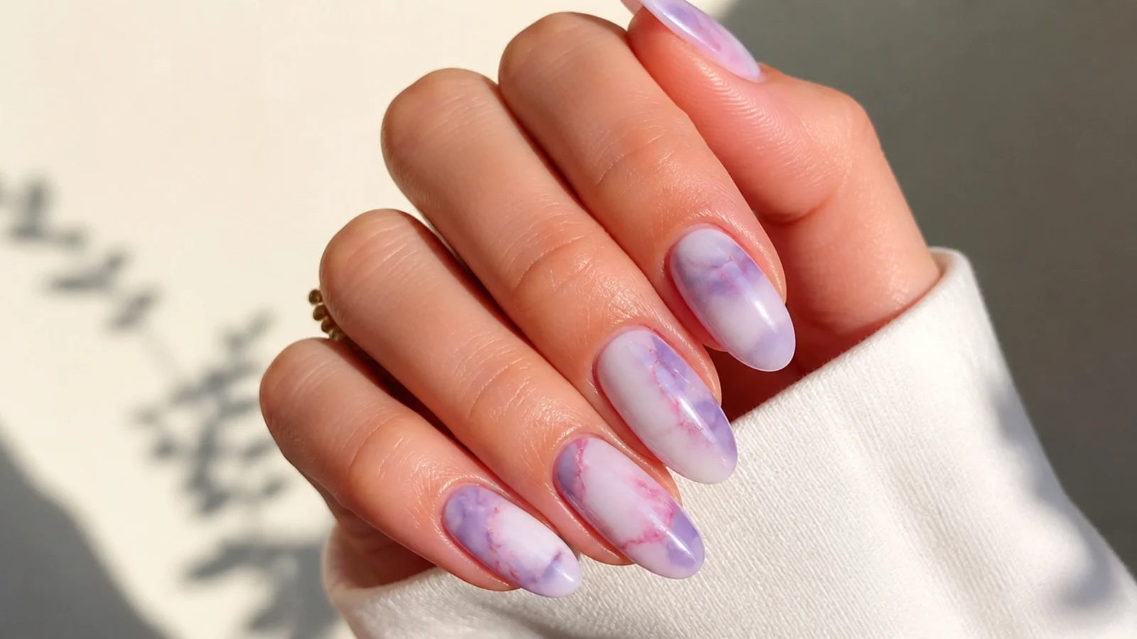 Soft lavender and pink marble nails with hazy veining on white