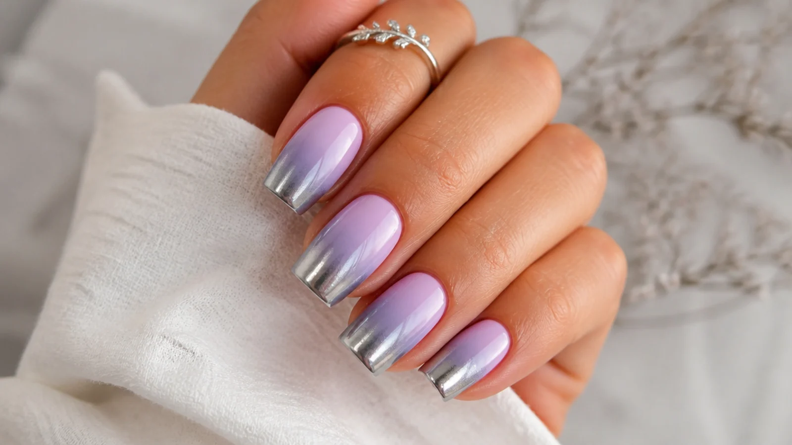 Lavender ombre nails fading into a silver chrome tip on square nails