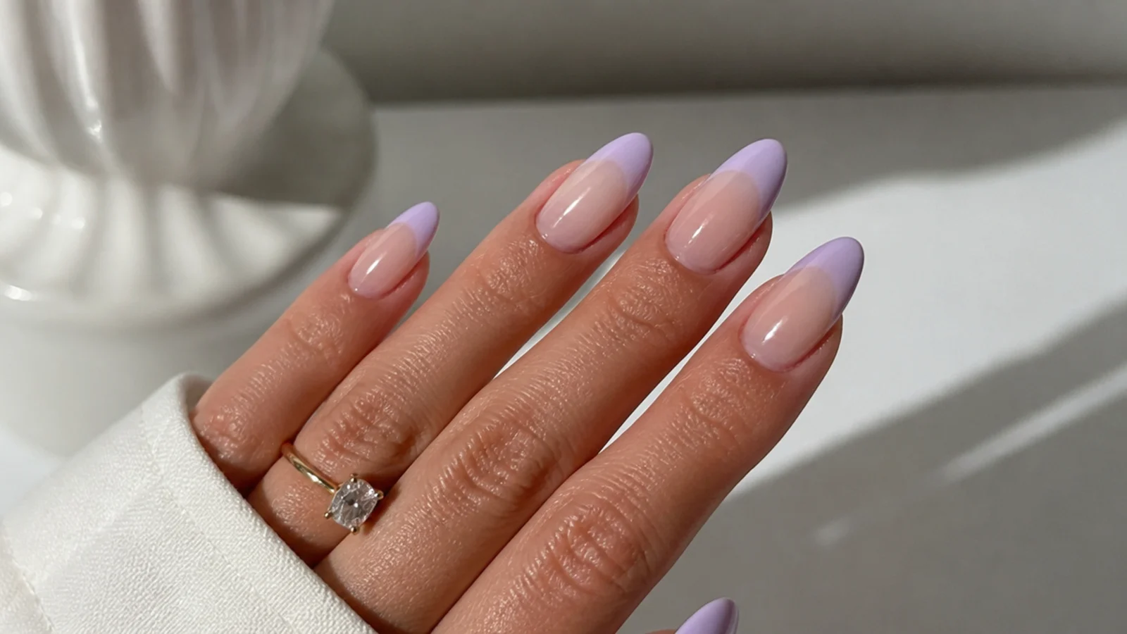 Soft French ombre with a lavender-tinged white tip on almond nails