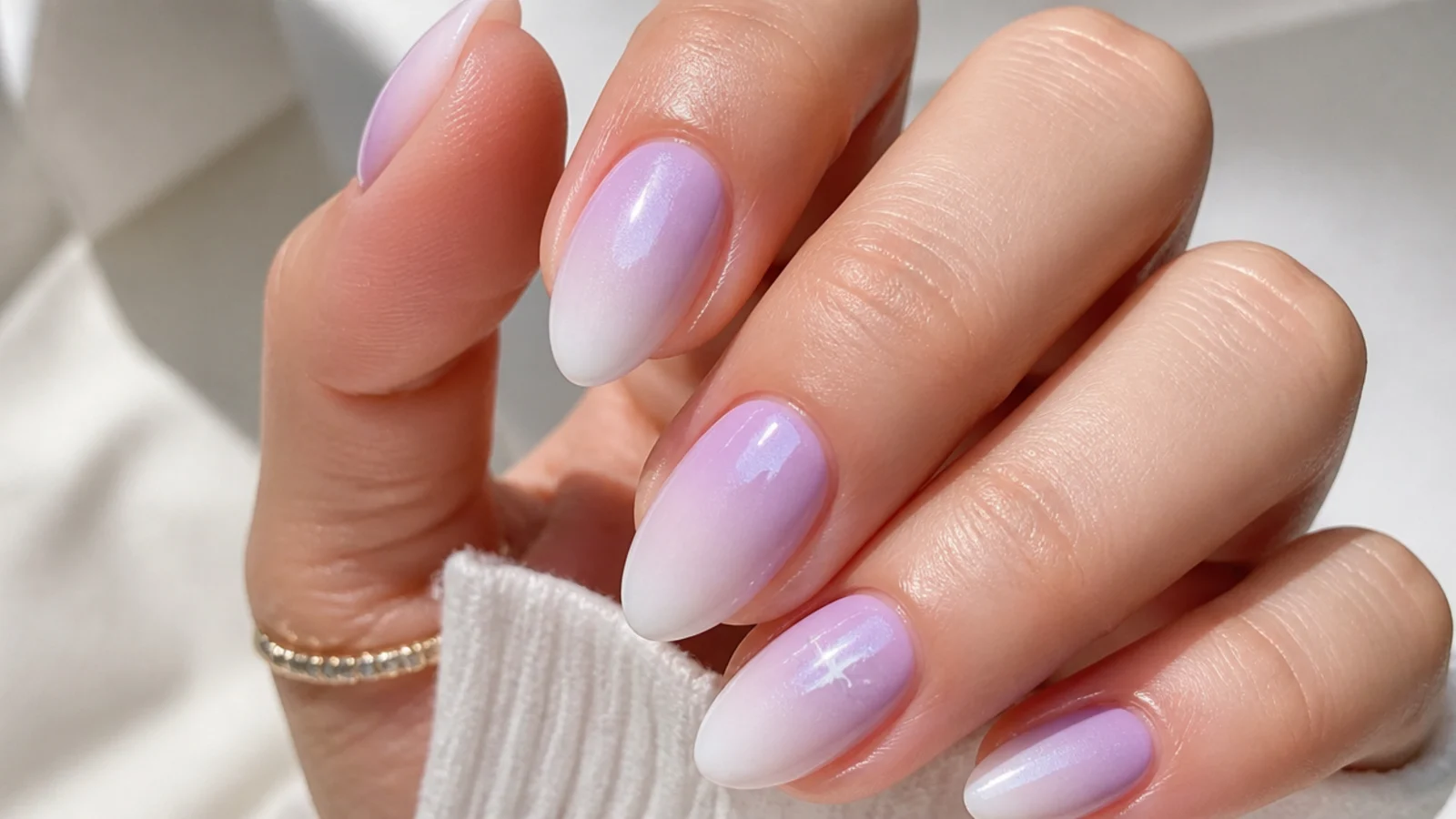 Soft lavender ombre nails fading from lilac into white on almond tips