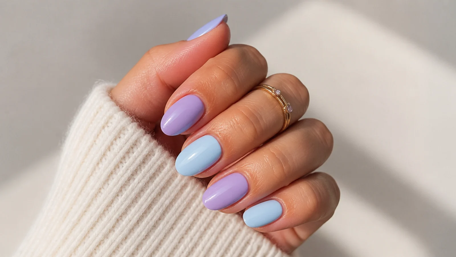 Alternating lavender and baby blue pastel nails on a short almond shape