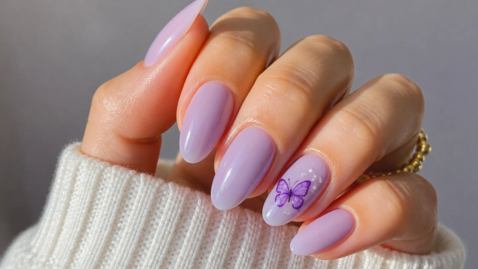 Milky lavender nails with a small hand-painted purple butterfly accent