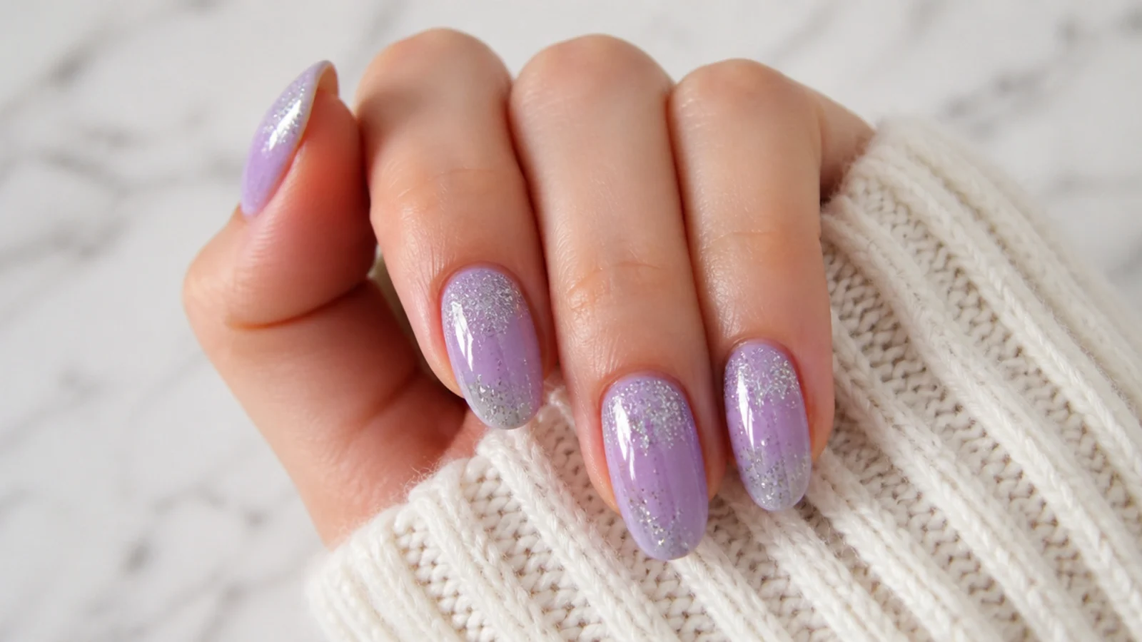 Soft lavender nails with fine silver glitter fading from the tips