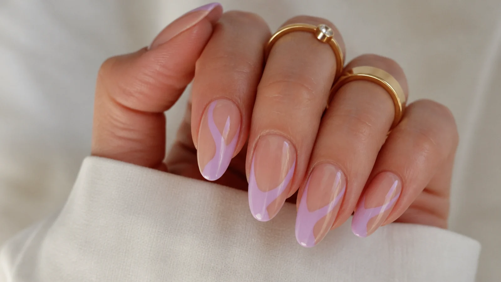 Sheer nails with lavender negative-space swoops and bare gaps