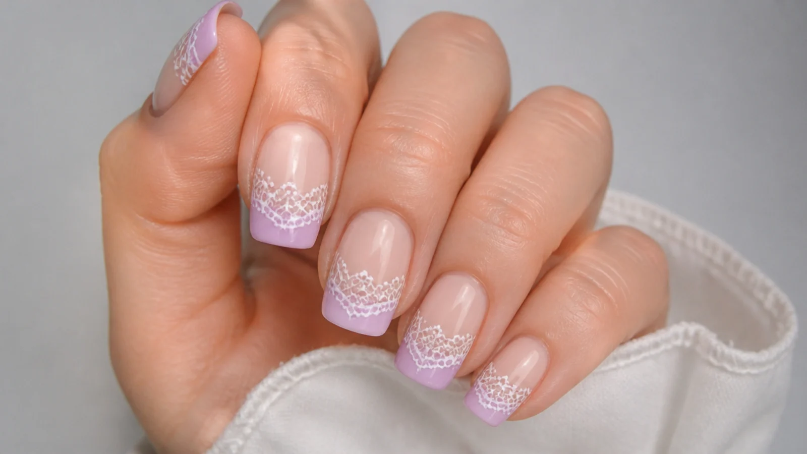 Sheer nails with delicate white lace detailing over lavender tips