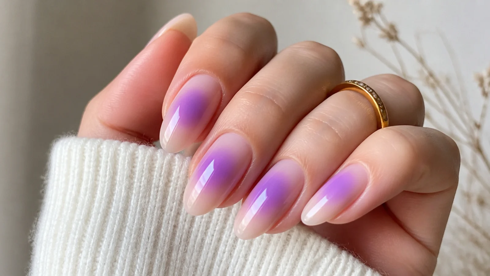 Nails with a soft lavender aura glow blurred at the center over a nude base