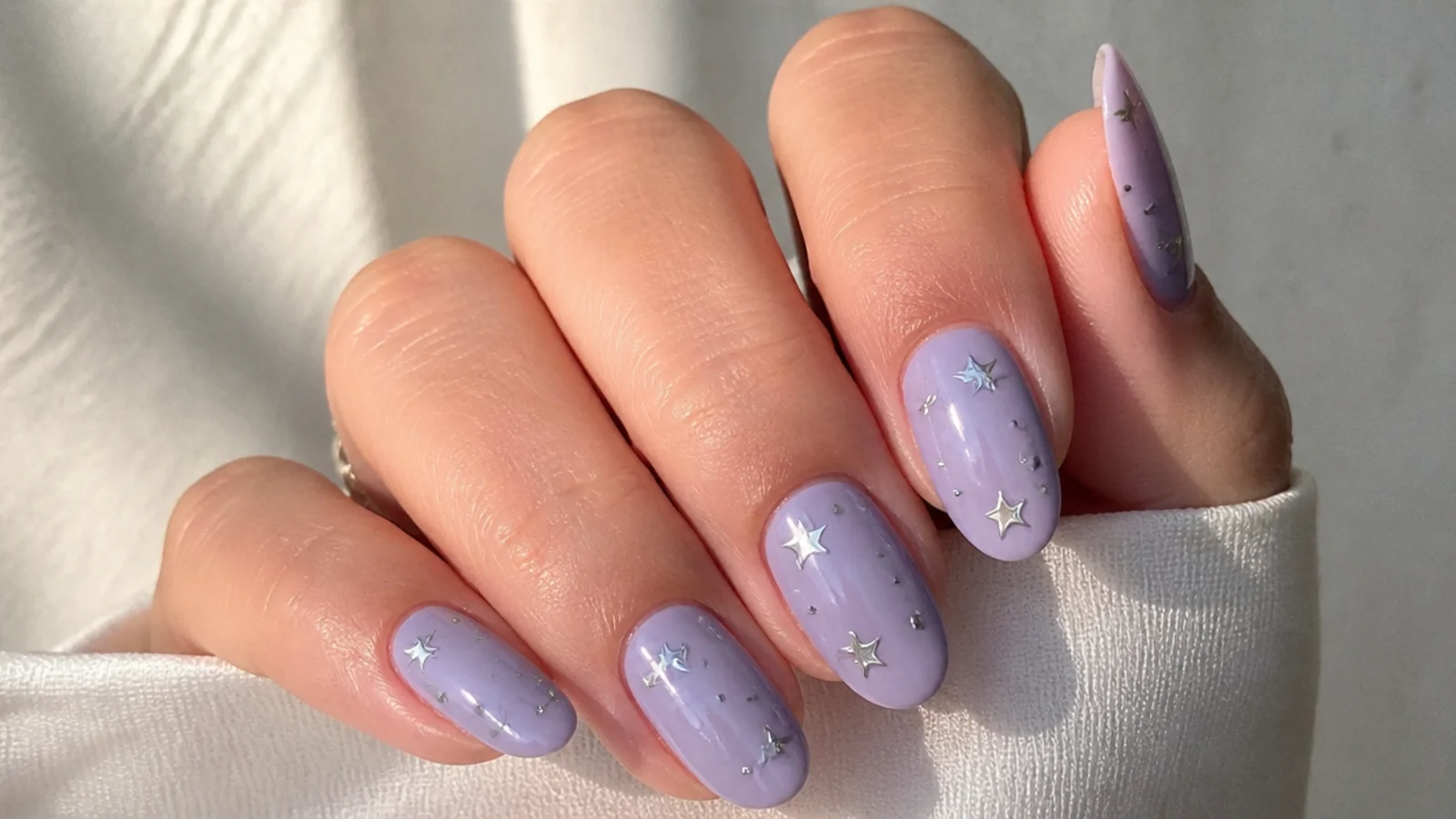 Soft lavender nails with tiny silver star and dot accents