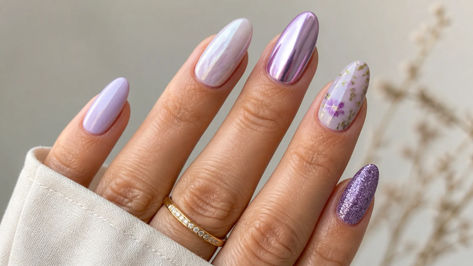 Five lavender nails each in a different finish from milky to chrome to floral