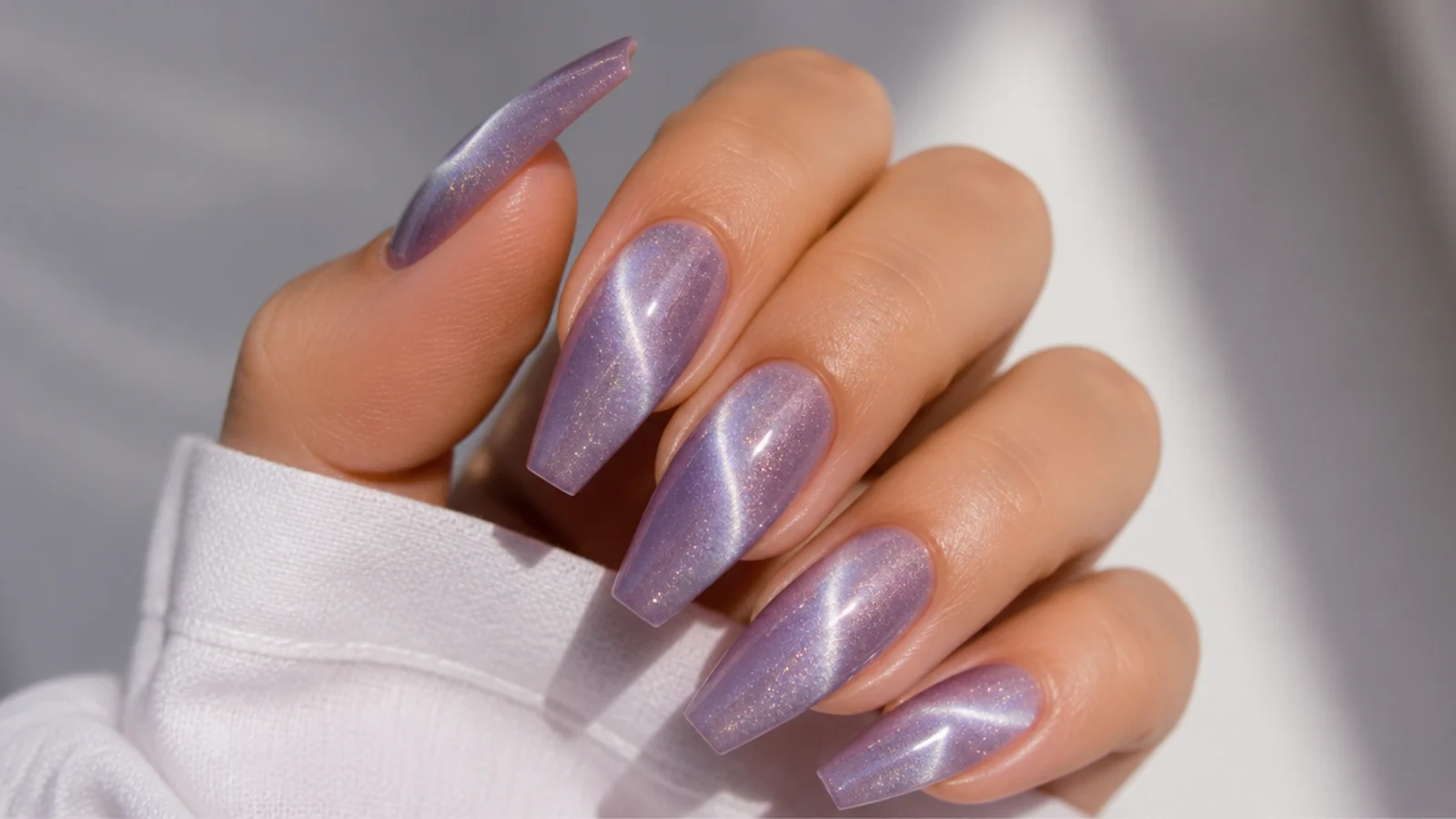 Light lavender cat-eye nails with a shifting light band across coffin nails