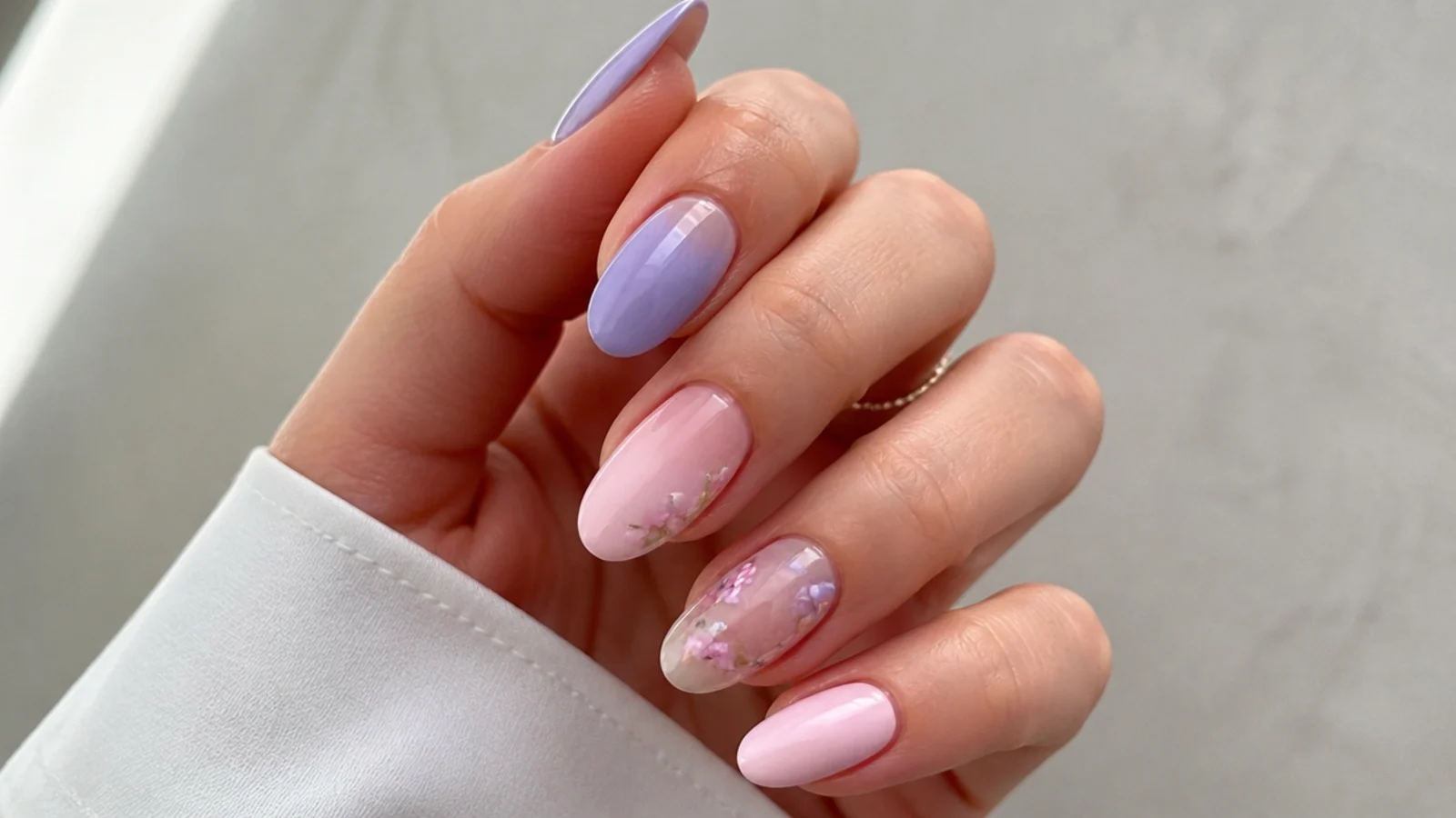 Light lavender and soft pink alternating pastel nails on almond nails