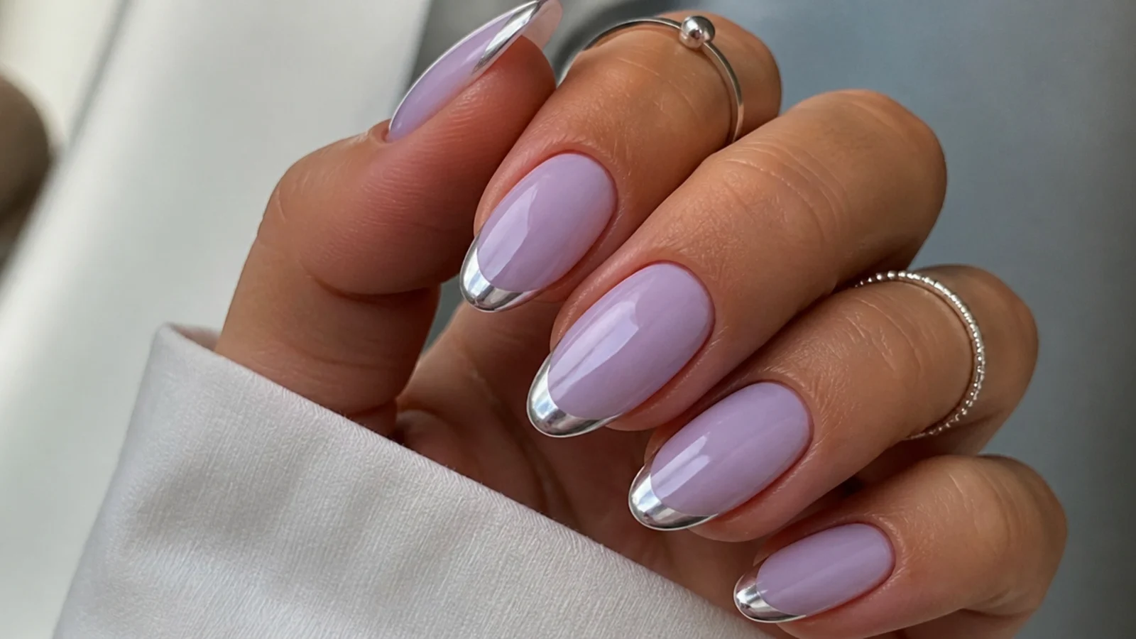 Milky lavender nails with a thin silver chrome tip