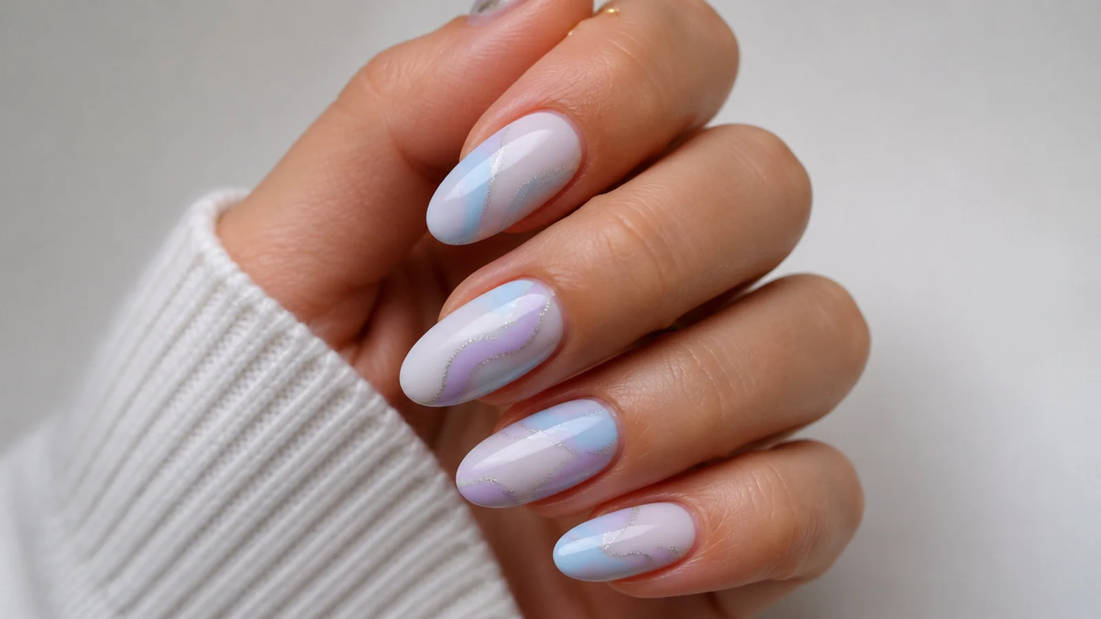 Milky lavender and baby blue swirl nails on a soft white base