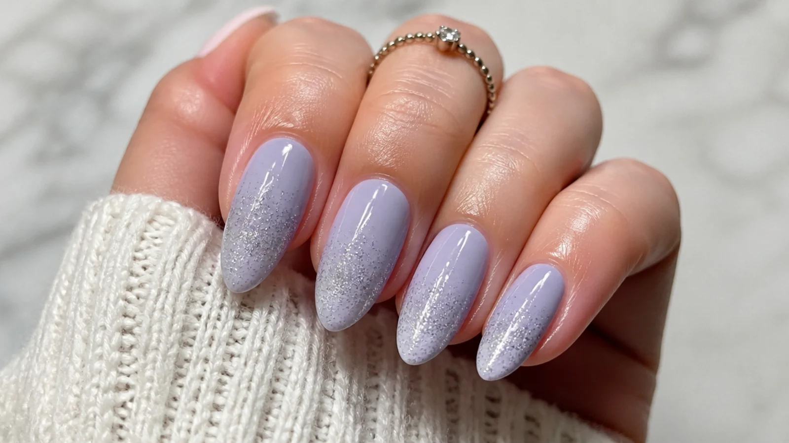 Milky lavender nails with silver glitter fading up from the tips