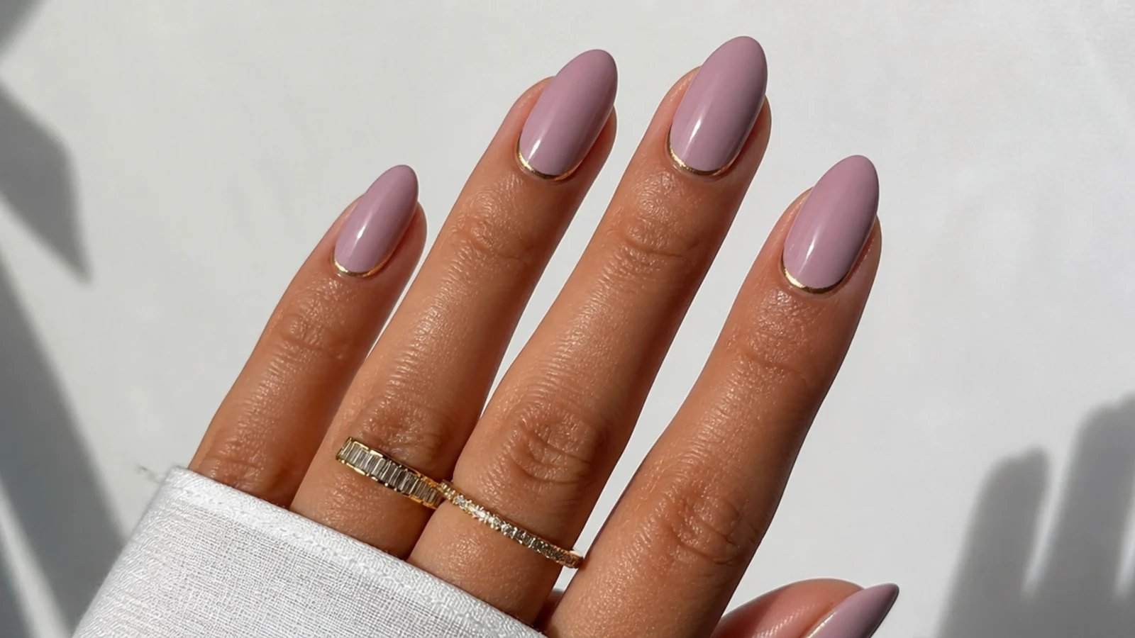 Warm pink-lavender nails on tan skin, almond shape