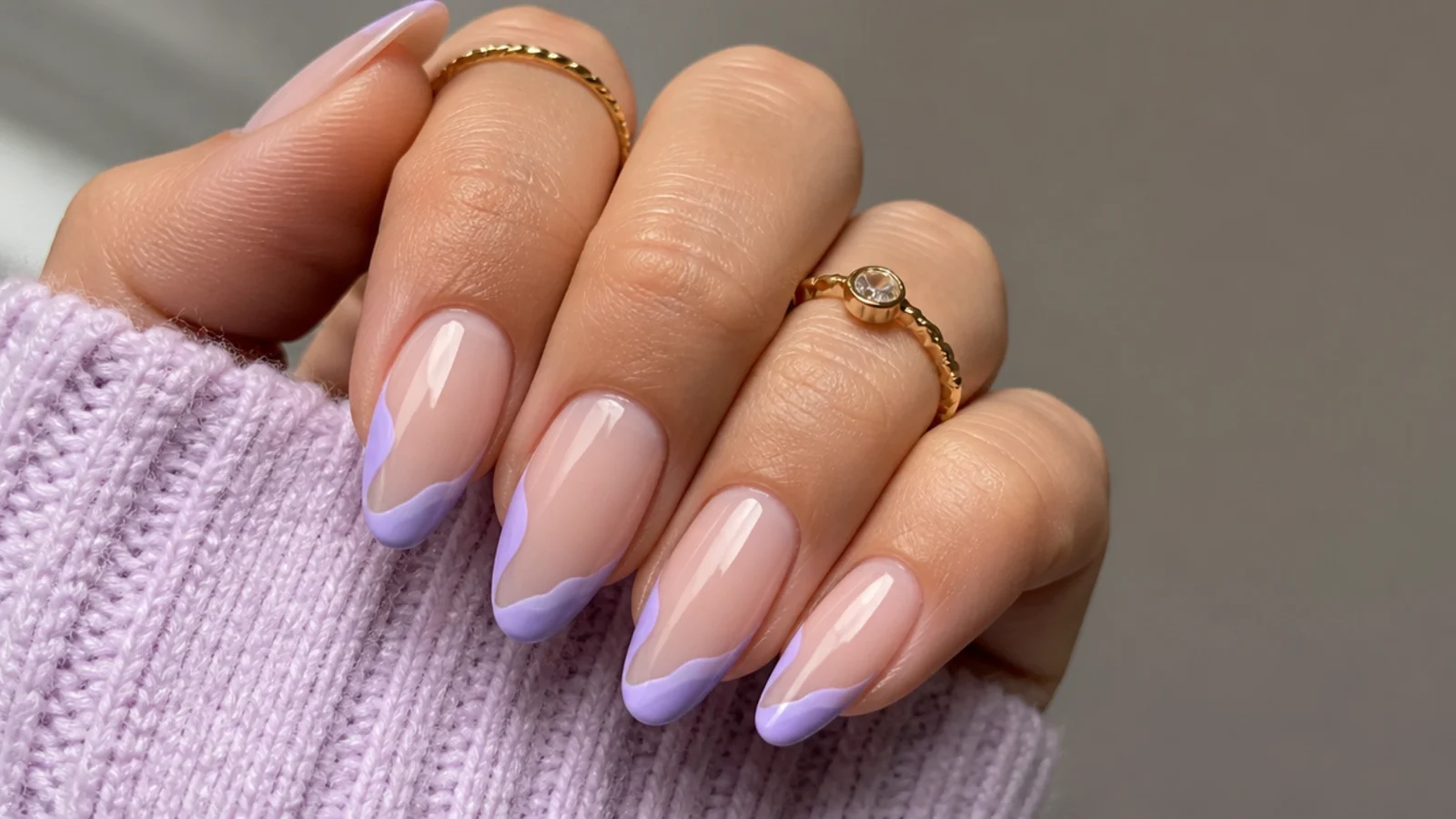Milky nails with a wavy lavender swirl tip instead of a straight French, almond shape