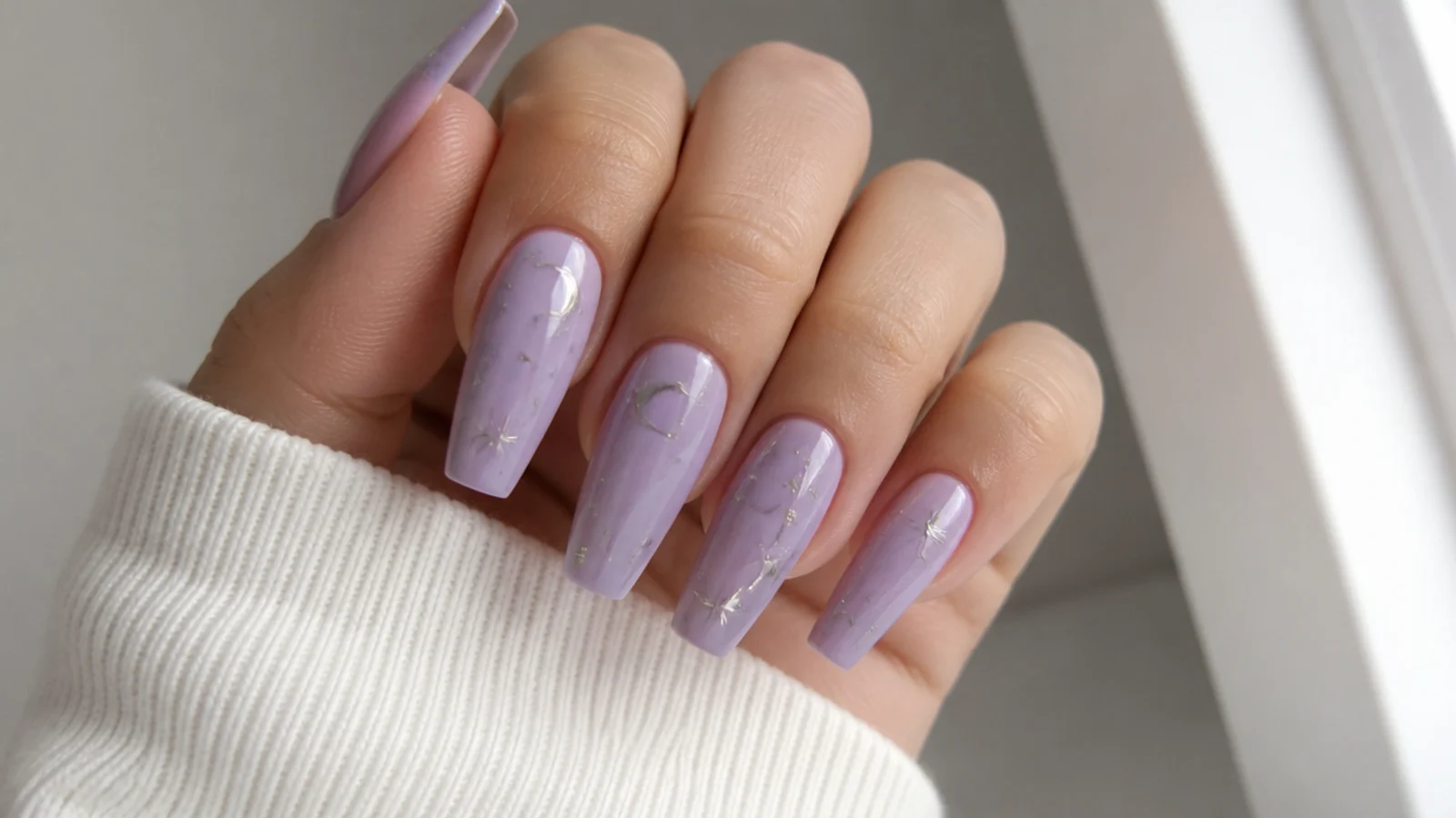 Pastel lavender nails with tiny silver star and celestial accents, coffin shape