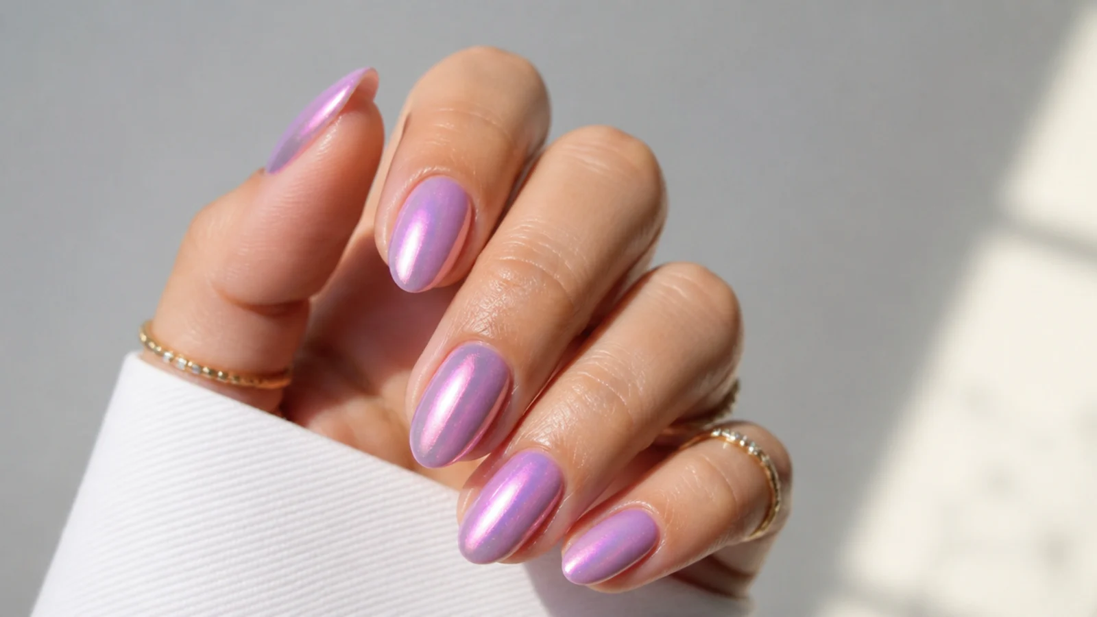 Glazed lavender chrome nails with a pink pearl shift on short almond nails
