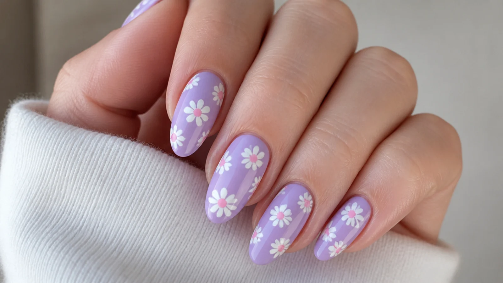 Small white daisies with pink centers on a lavender base, almond nails