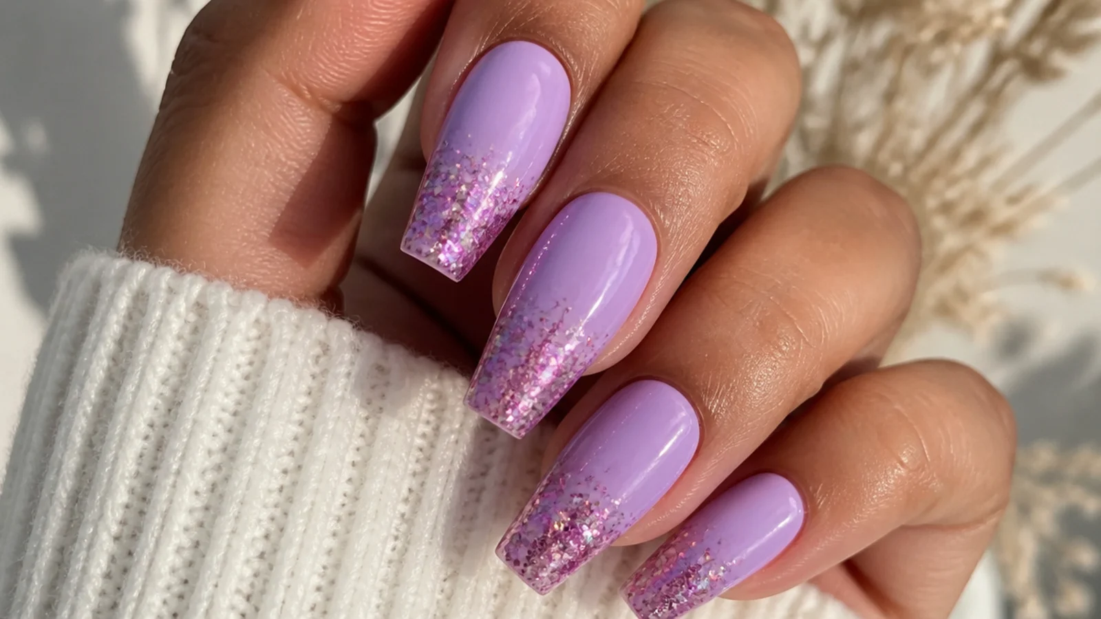 Lavender nails with pink glitter fading from the tip on coffin nails