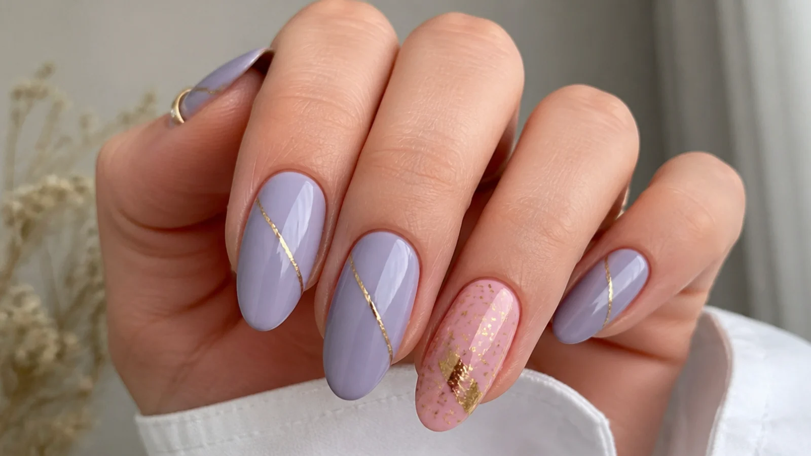 Lavender nails with thin gold foil lines and a pink accent nail