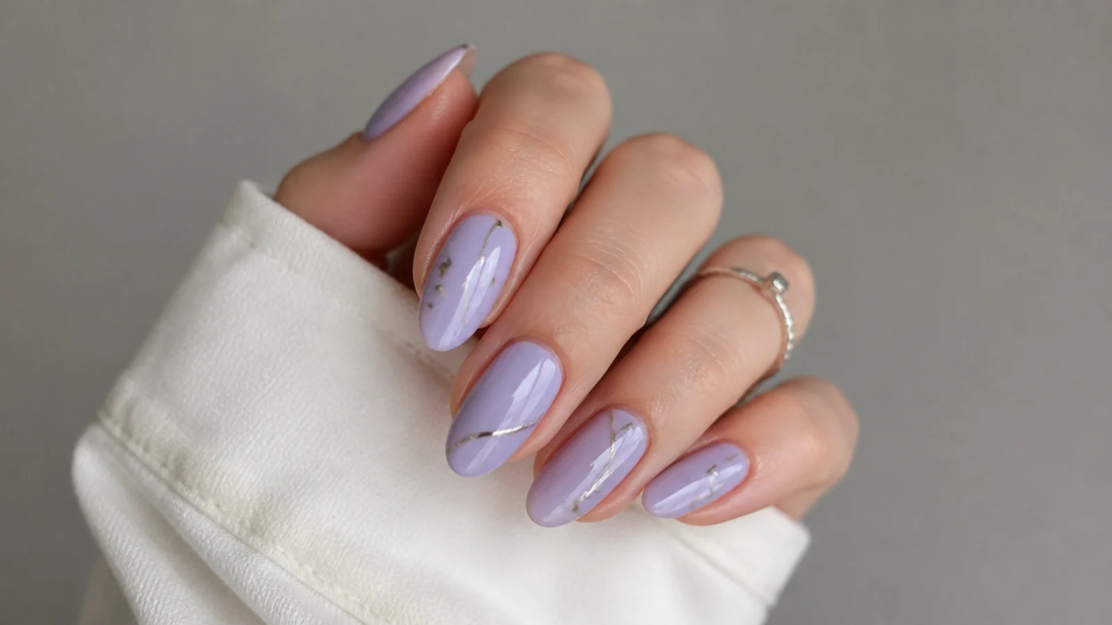 Soft lavender nails with thin silver line and stud accents