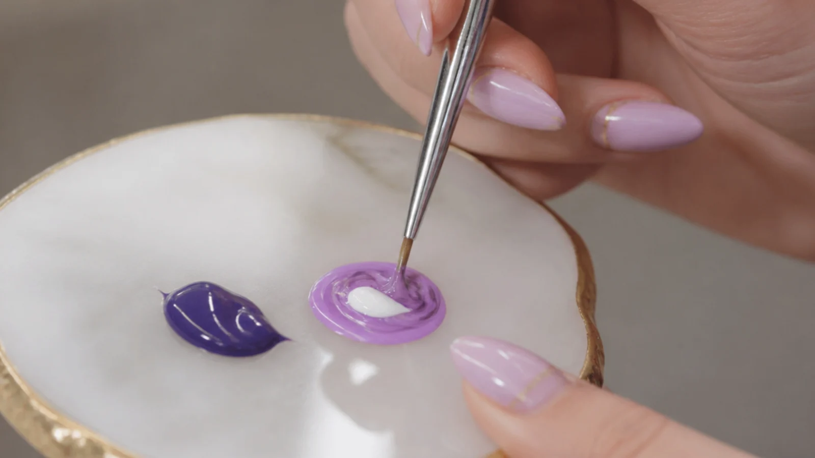 A drop of white gel being mixed into purple to reach a custom light purple shade