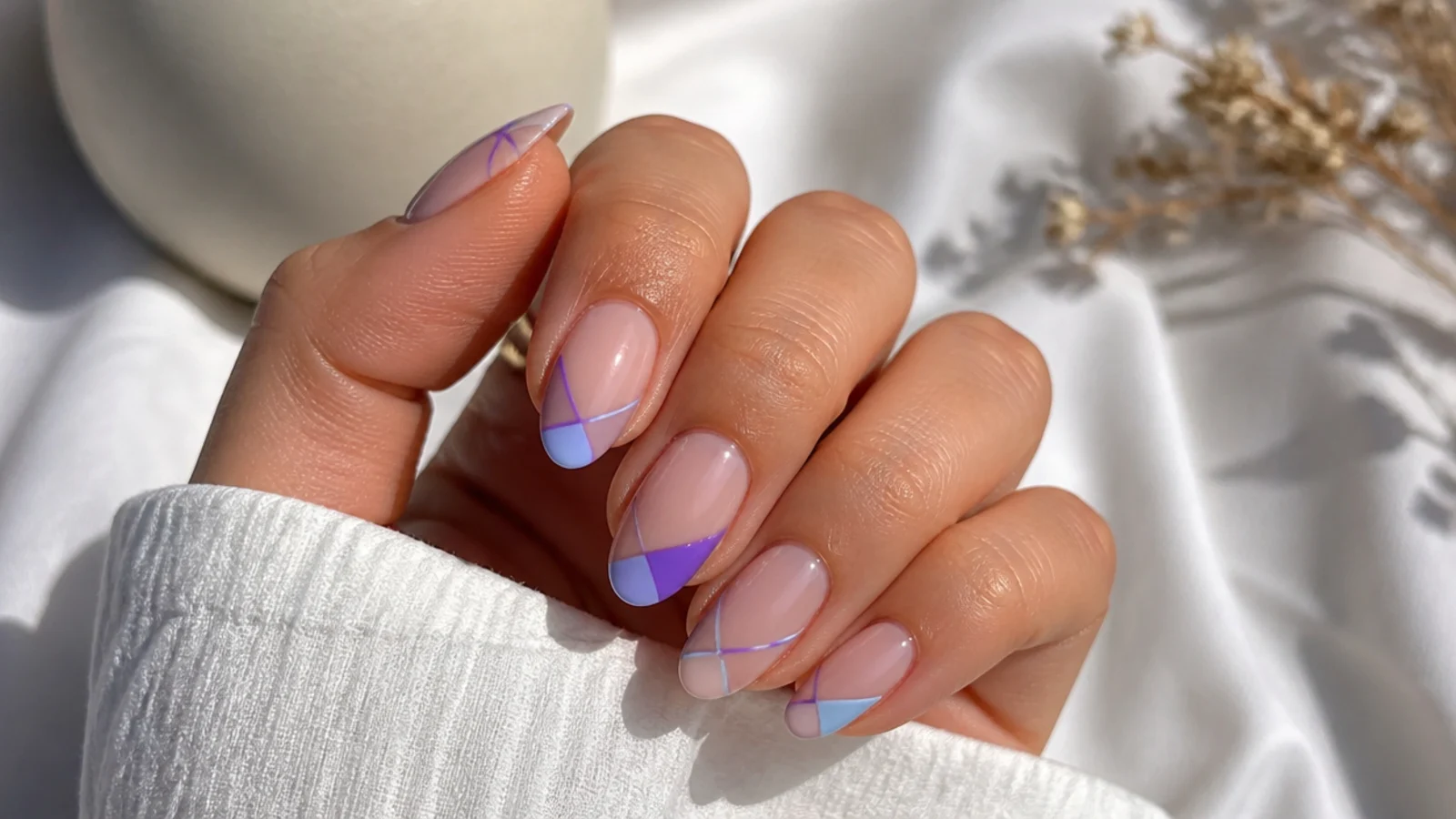 Negative space nails with light blue and purple geometric accents