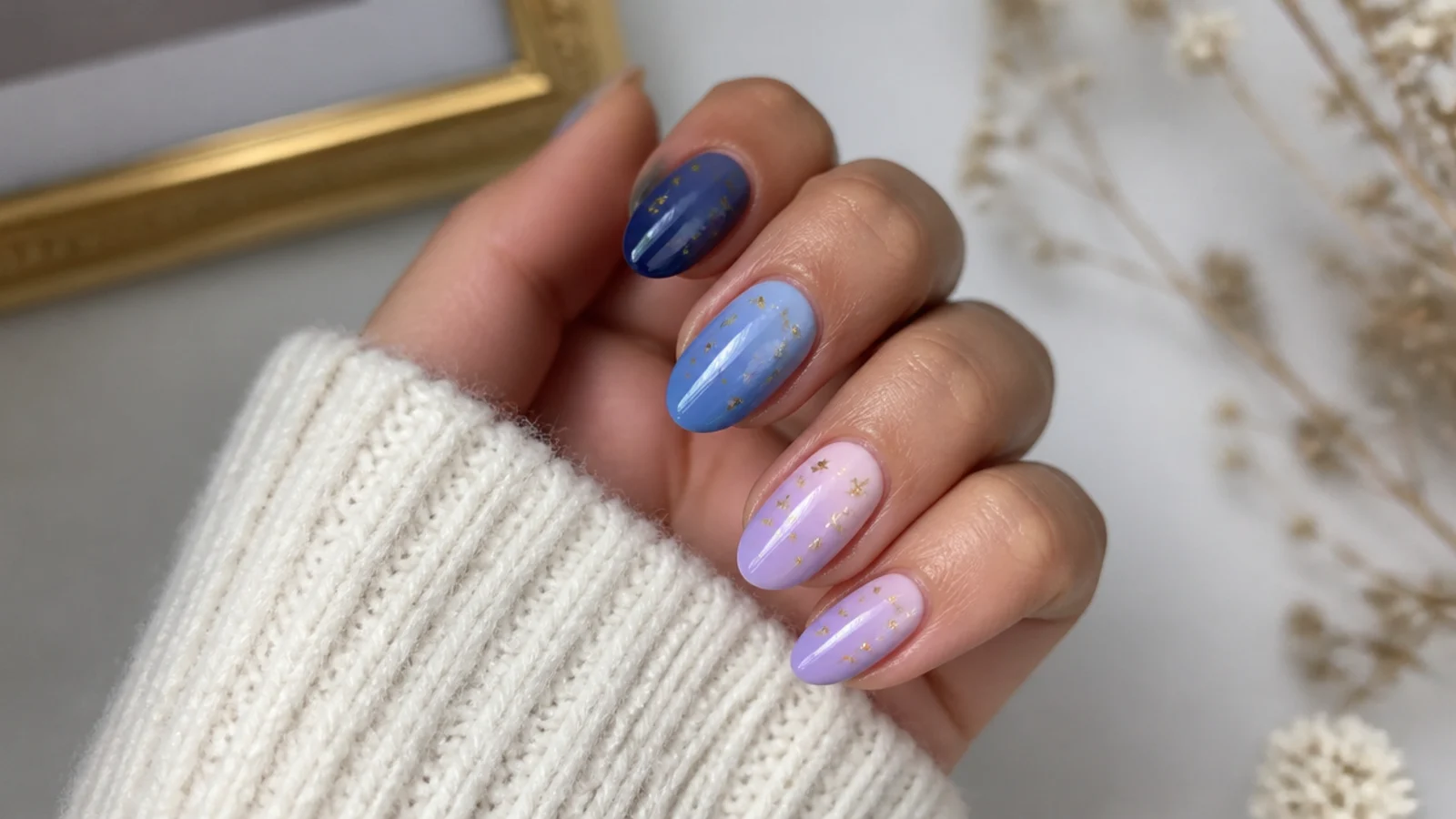 Deep-to-light blue and purple nails with tiny gold stars