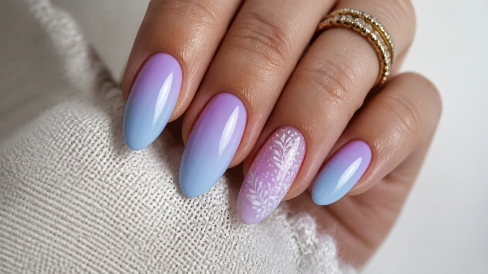 Soft pastel light blue and purple ombre nails on an almond shape
