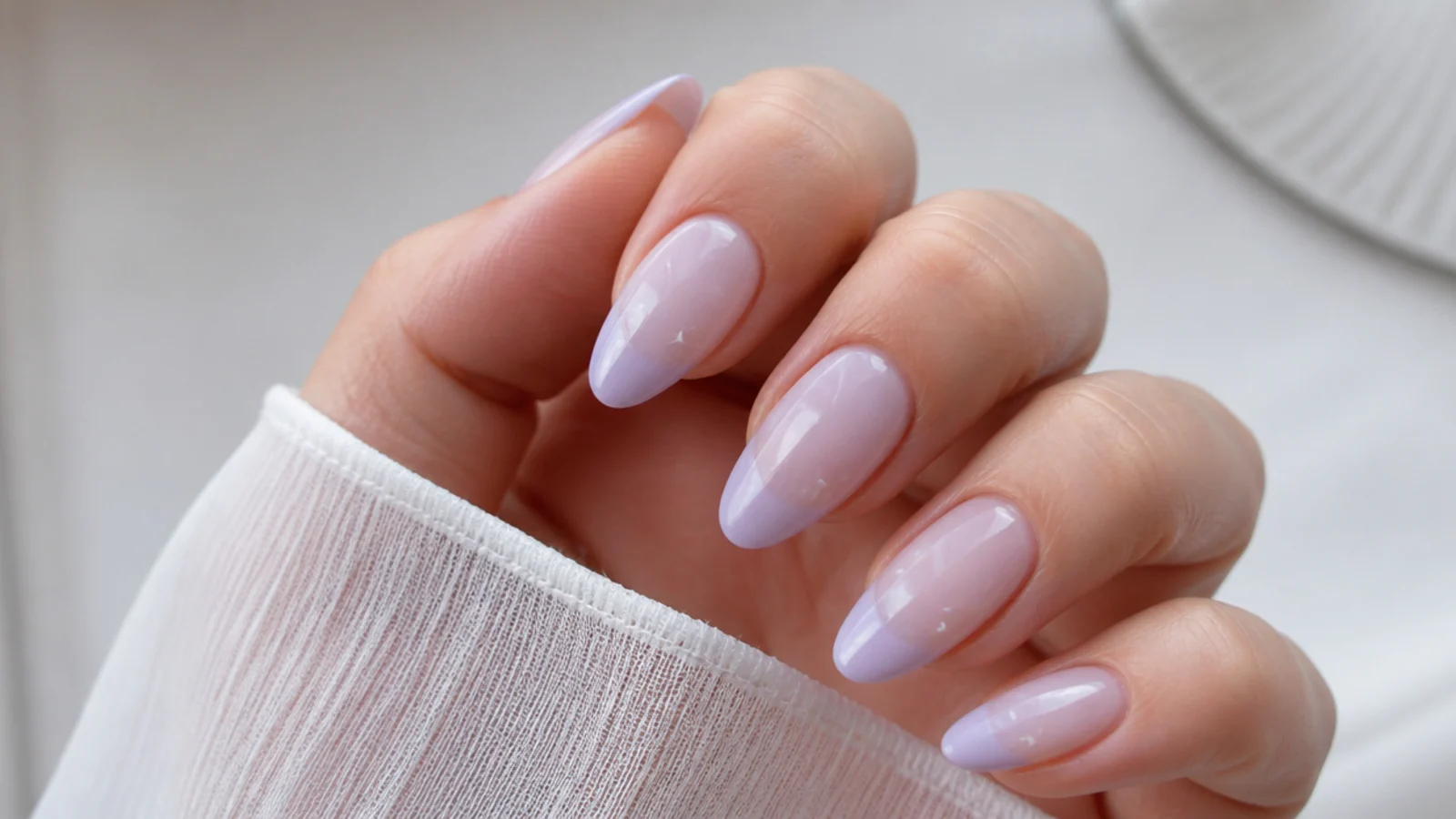 Milky sheer lilac acrylic nails in a medium almond shape