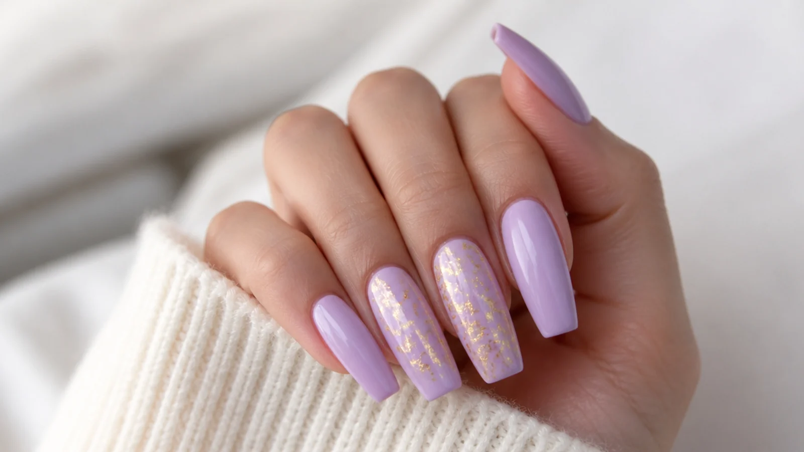 Lavender acrylic nails with thin gold foil flakes on two nails