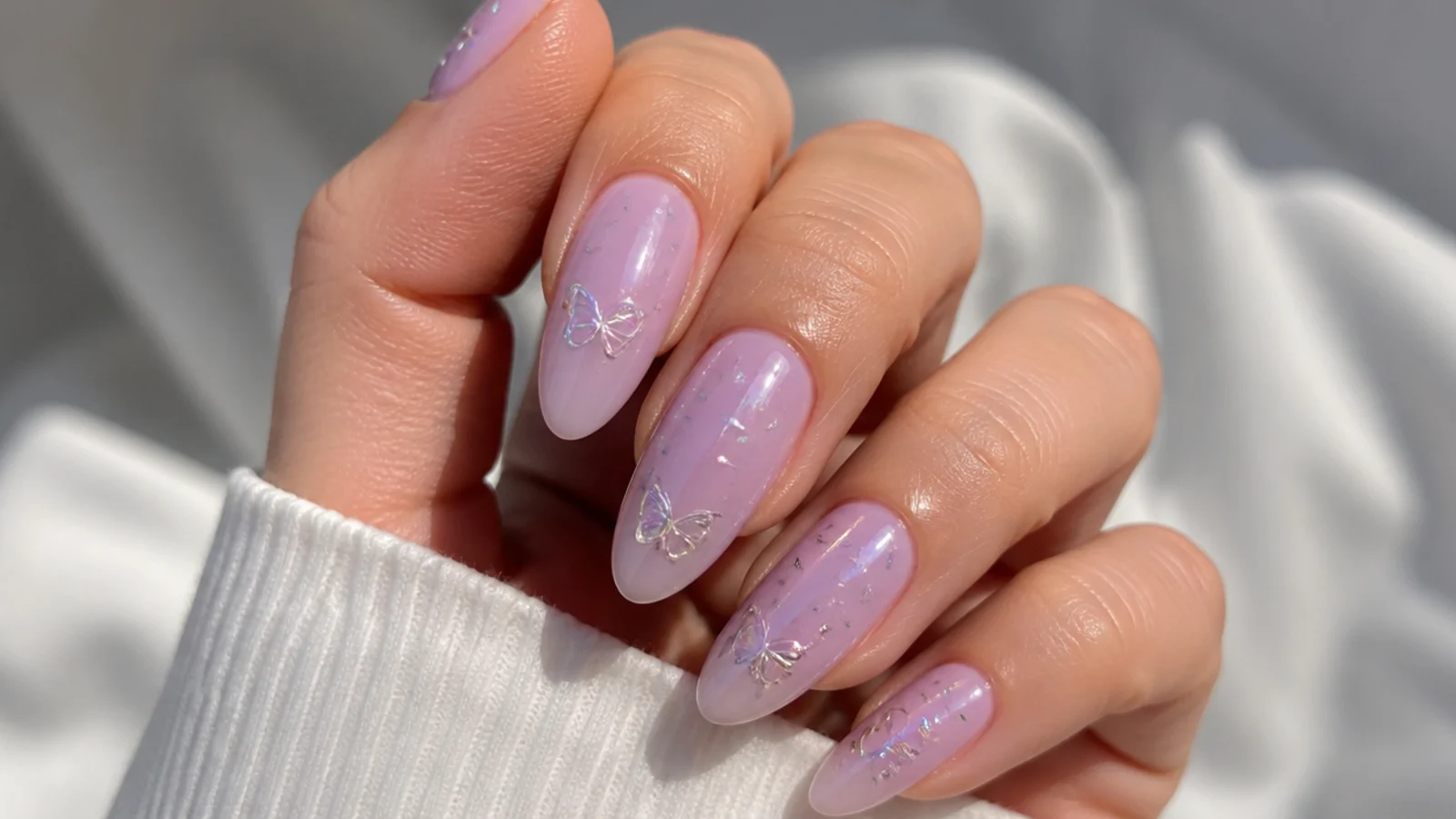 Soft light purple acrylic nails in a milky lilac almond shape